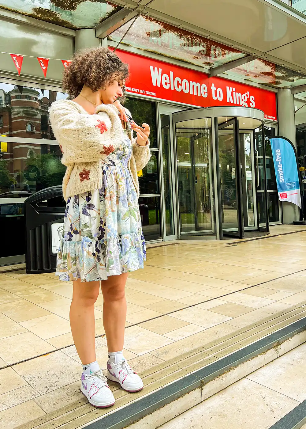 King's College London social media interviewer adjusting her mic outside campus - KCLSU 2023.