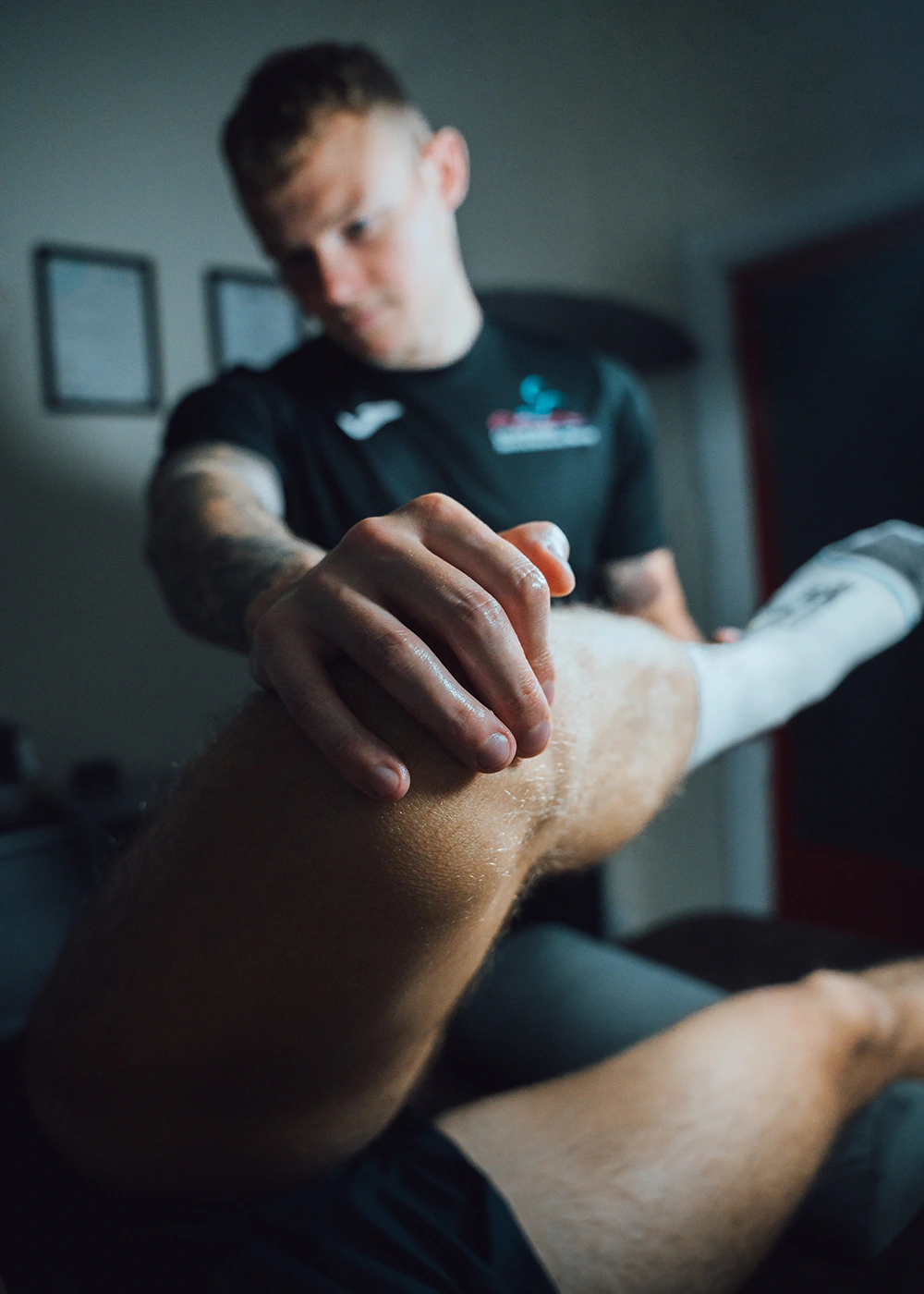 Callum Wood Sports & Structural Therapy performing a sports massage and stretching the leg on a client.